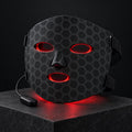The Mog Mask: a black LED face mask with a grey hexagon pattern, glowing red